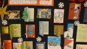 Kartki na gazetce szkolnej z nazwą konkursu Christmas Card