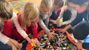 Dzieci owierają wielki worek z klockami Lego
