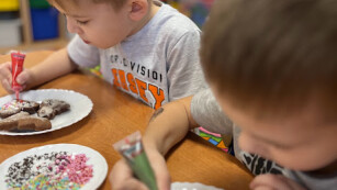 Chłopiec kreślący wzory na pierniczku przy użyciu lukru