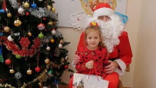 Dziewczynka w czerwonej sukience z Mikołajem