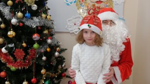 Dziewczynka w czapce mikołajowej z Mikołajem