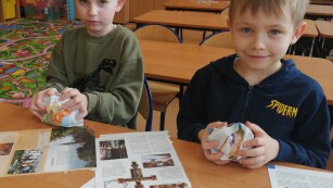 Chłopcy formują papierowe kule na pączki
