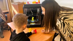 Nauczycielka z chłopcem przy drukarce 3D