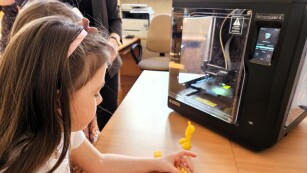 Dziewczynka podziwiająca figurkę Myszki Miki z drukarki 3D