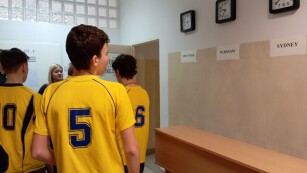 Chłopcy w ubraniach sportowych na korytarzu szkolnym.
