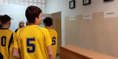 Chłopcy w ubraniach sportowych na korytarzu szkolnym.