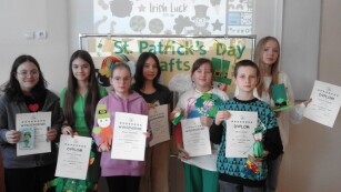 Uczniowie pozują do zdjęcia z otrzymanymi dyplomami za konkurs St. Patrick's Day Crafts.