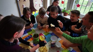 Uczniowie macczają kukurydziane chrupki w ciepłej czekoladzie.