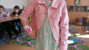 Dziewczynka w różowej katanie pozuje do zdjęcia