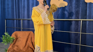 Chłopiec w żółtej sukience mówiący wiersz