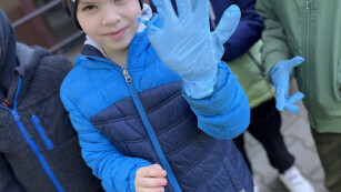 Chłopiec pozujący do zdjęcia z niebieską rękawiczką