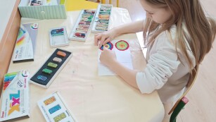 Dziewczynka malująca farbami kolorowe koła