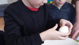 Uczeń wbija jajko do miski.