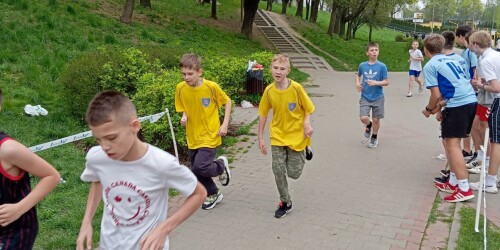 Uczniowie w koszulkach sportowych na ścieżce.